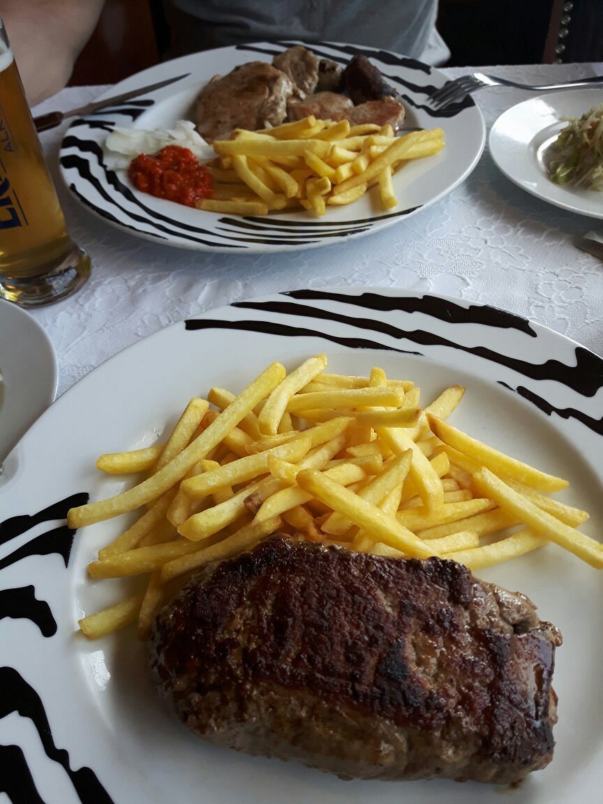 Tisch im Cafe Marlene mit zwei vollen Sektgläsern und Bierdeckeln auf den steht, Cafe Marlene, Jeden Sonntag ab 11:00 h Frühschoppen, dazu 2 volle Bierkrüge abgebildet.